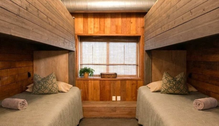 Bunk room with twin beds and wood paneling