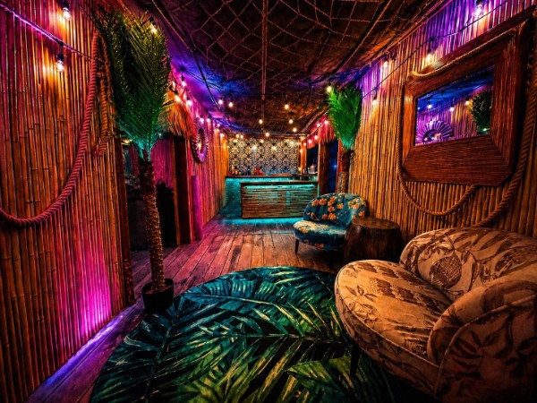 Tiki bar lounge with bamboo walls and neon lighting